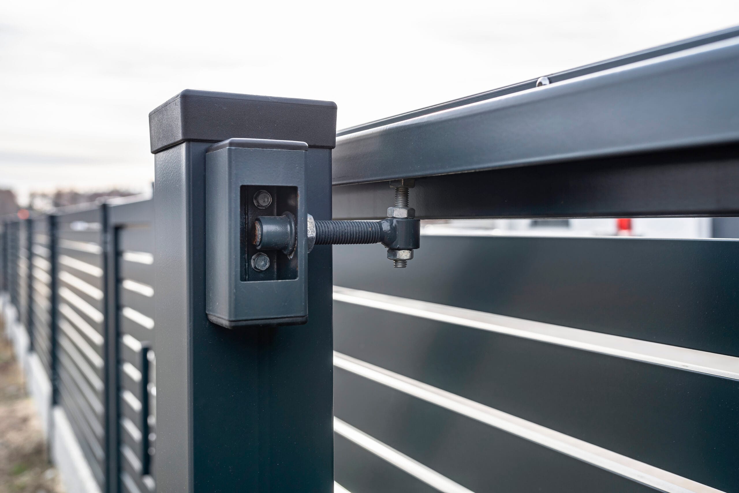 Modern sliding entrance gate in anthracite color, visible upper guide rollers. Modern sliding entrance gate in anthracite color, visible upper guide rollers.