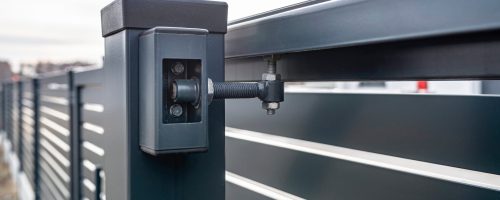 Modern sliding entrance gate in anthracite color, visible upper guide rollers.